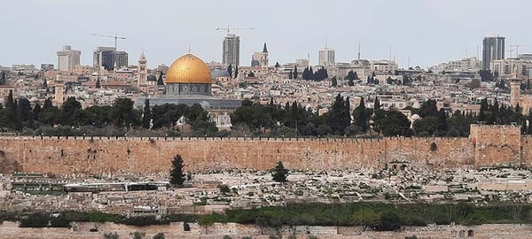 Golden Dome of the Rock behind Jerusalem's Old City wall, with the modern city skyline beyond