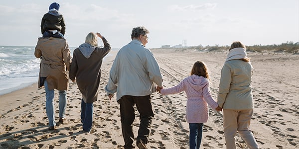 Multi-generational family walking on beach