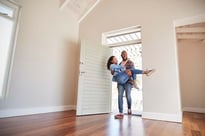 Newlywed couple walking into their new home