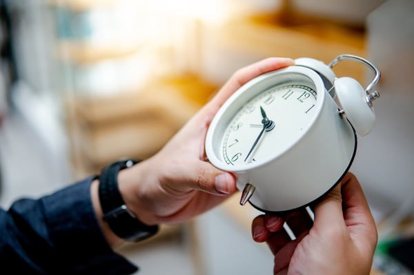 Hands holding clock