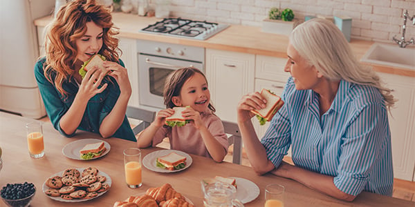 Three generations of women eating sandwiches