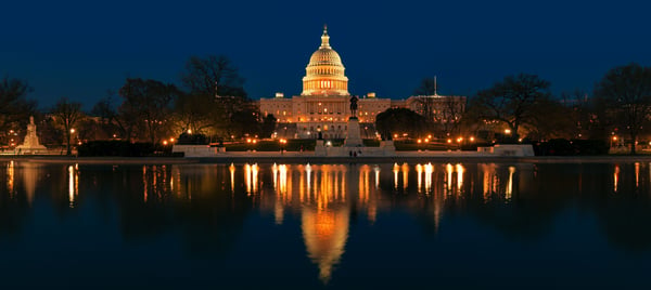 U.S. Capitol building lit up at night and reflected in the Capitol Reflecting Pool