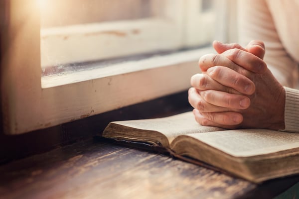 A woman resting her hands on the Bible. 