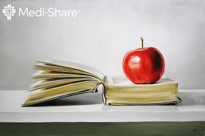 Apple sitting on open Bible