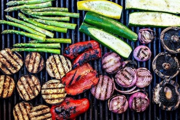 Grilled asparagus, zucchini, eggplant, red peppers, red onions and mushrooms on a grill grate
