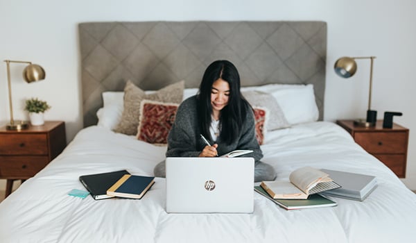lady using laptop on bed
