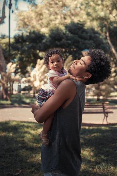 Young black father carrying baby outside