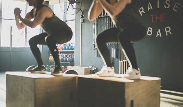 two women doing box jumps