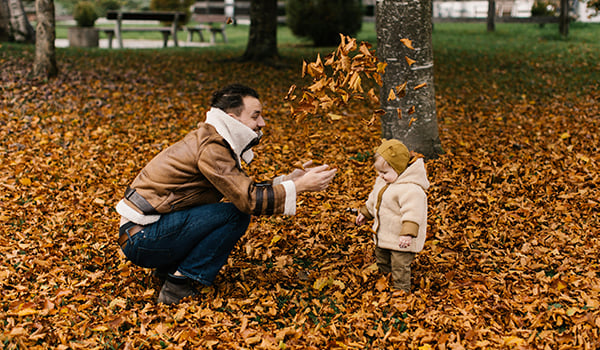 Dad playing in leaves with daughter