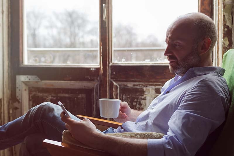 Man drinking coffee alone in his study