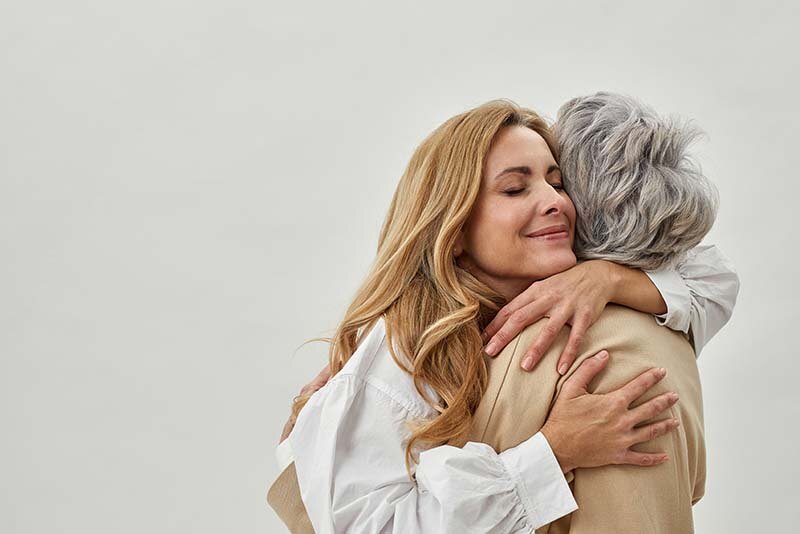 Younger woman hugging older woman