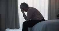 Exhausted woman on the edge of her bed