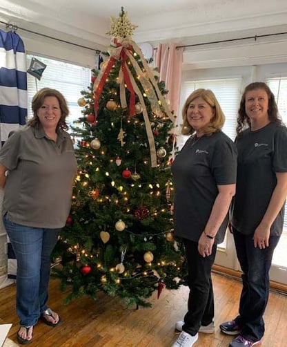 Ladies standing next to Christmas Tree