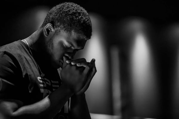 Man folding his hands to pray