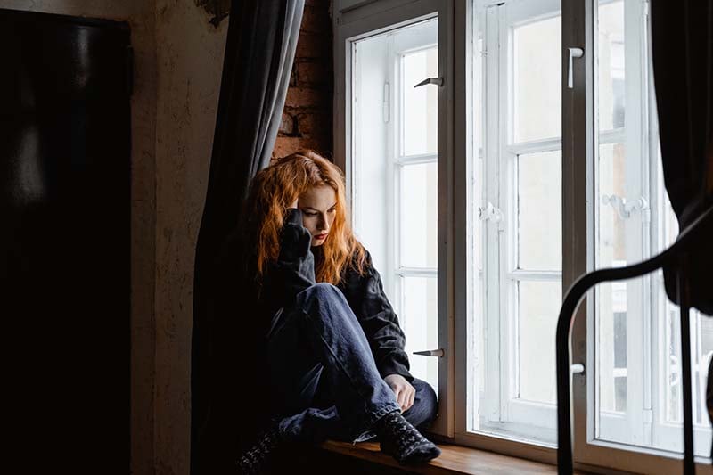 Woman feeling sad by a window