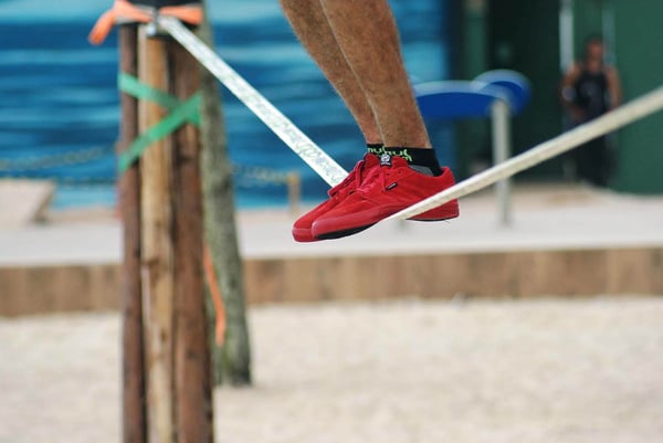 Man slacklining at the beach