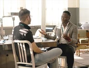 Mentor and mentee talking at a table