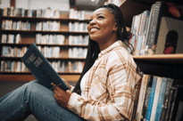 Woman sitting in a library reading about bible studies