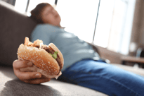 hamburger being held by a blurred out boy in the background