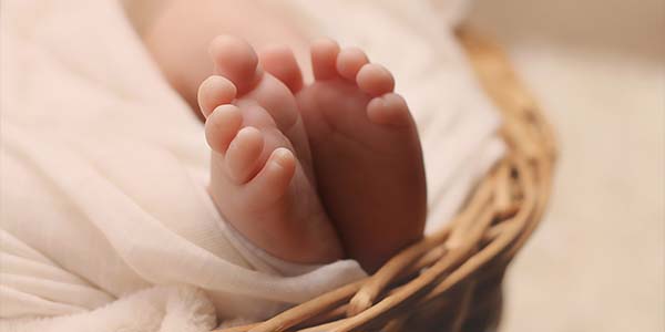 baby toes sticking out of a blanket in a basket