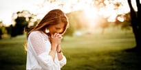 woman bowing her head in prayer 