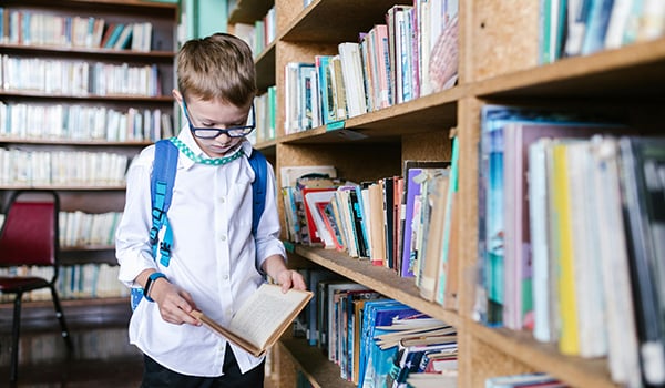 child looking at book in library