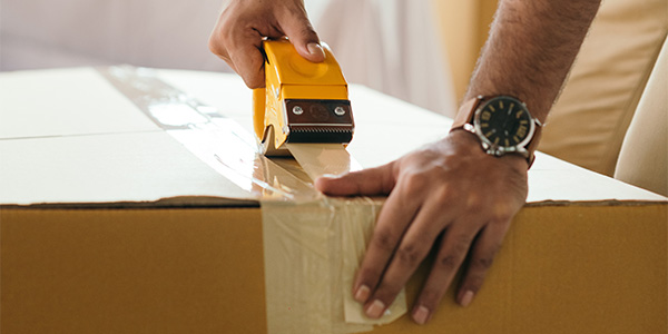 close up of hand taping up a box
