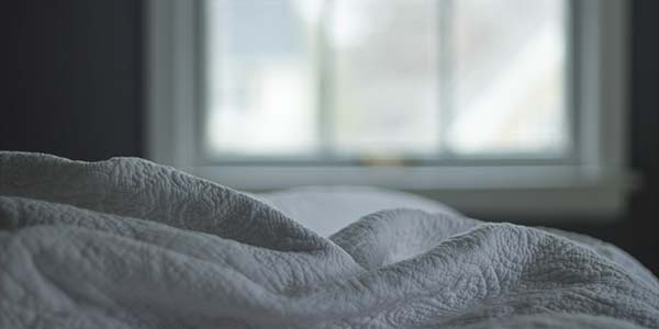 close up of white covers in a dimly lit room