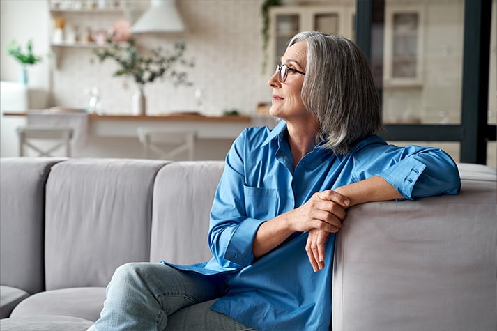 contemplative woman sitting on a couch