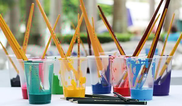 cups of paint with brushes
