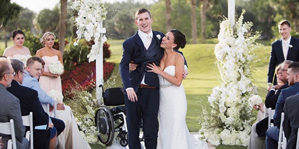 Chris and Emily Norton at their wedding, Chris standing beside his empty wheelchair, from the film 7 Yards