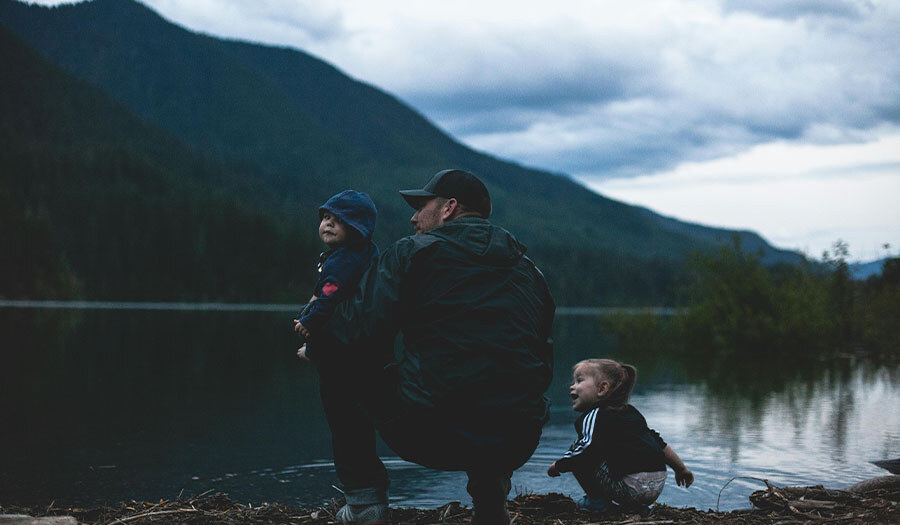 father with two kids at a lake