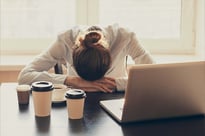 Fatigued woman with head down at work