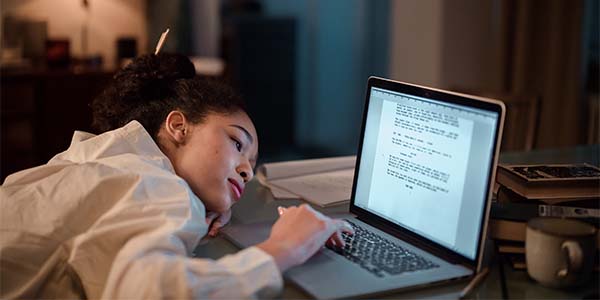 girl laying head down while on computer