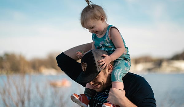 girl riding on dads shoulders