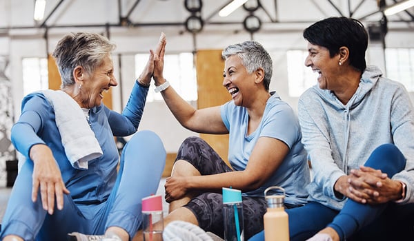 happy mature women celebrating at gym