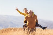 Happy grandparent giving piggyback ride to grandson