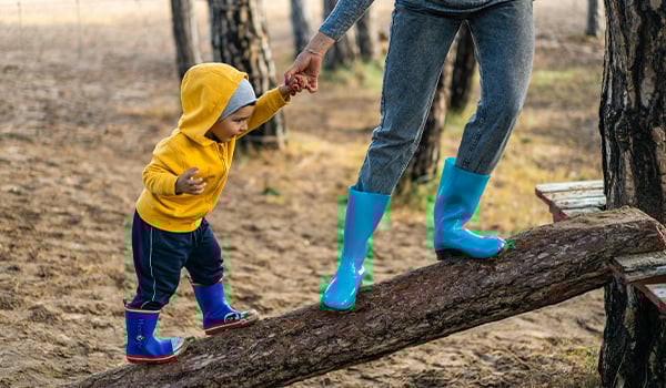 helping child up a balancing log