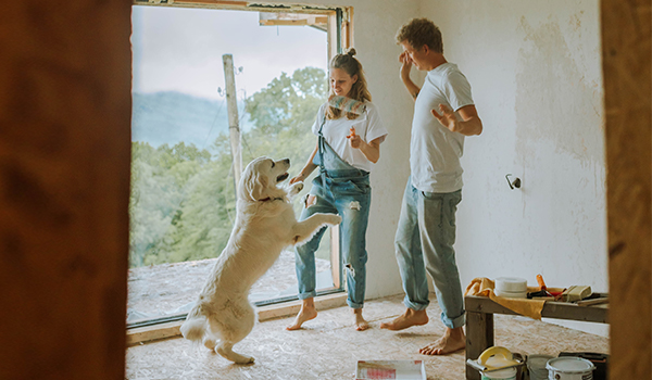 couple painting while playing with dog