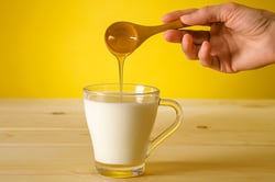 honey being added to milk