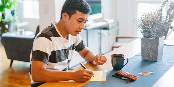 man doing paperwork at dining table