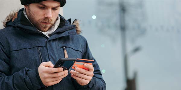 man holding credit card and phone