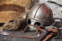 Knight's helmet and sword sitting on the ground
