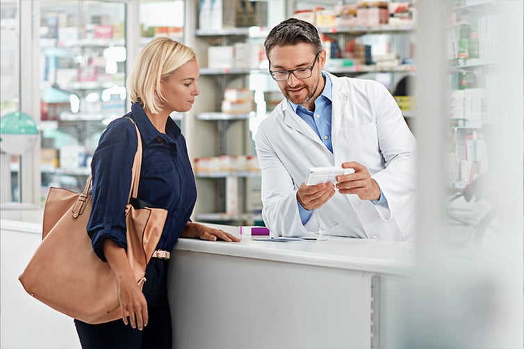 Male pharmacist explaining a prescription to a female patient