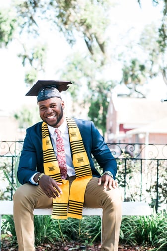 A young man posing at his college university.