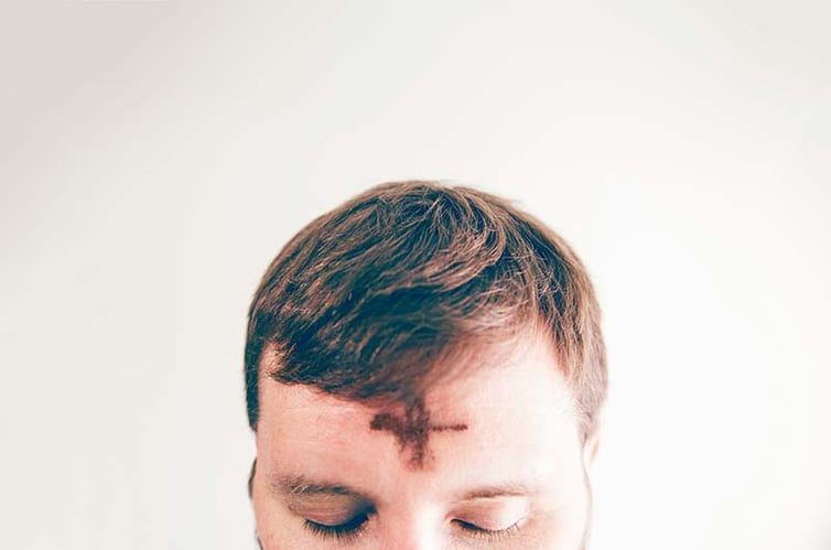 Man with ash-drawn cross on his forehead
