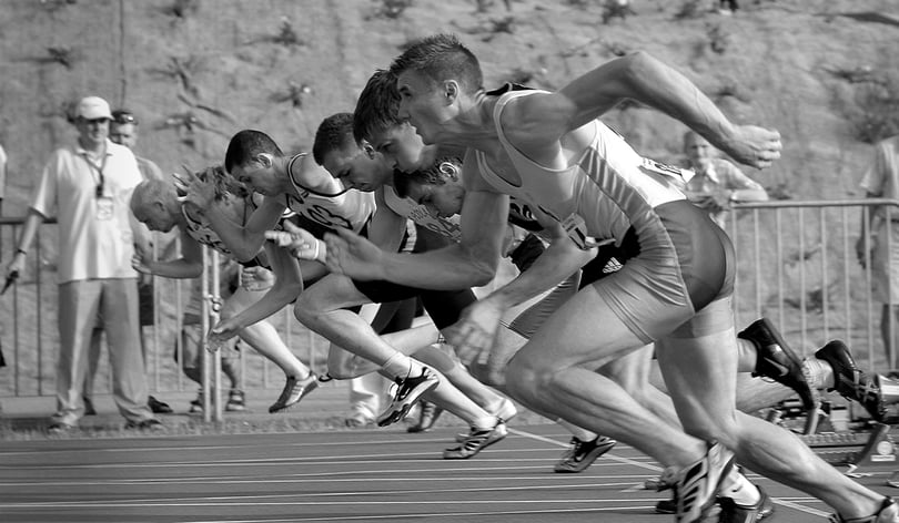 Sprinters bursting out of the starting blocks on a running track