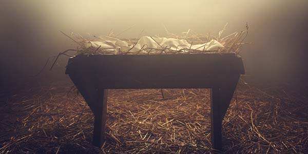 rustic wooden manger filled with straw and cloth