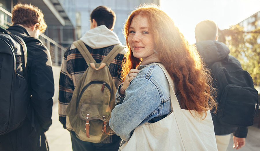 teen girl walking behind some boys