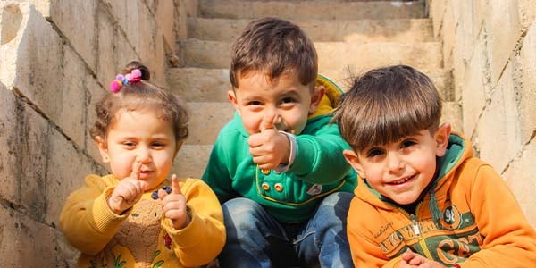 three children sitting on staircase